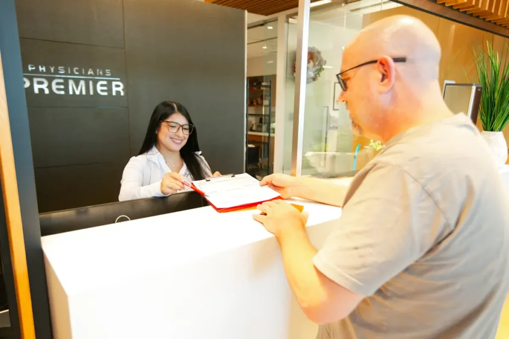 Medical assistant helping patient at Physicians Premier ER front desk